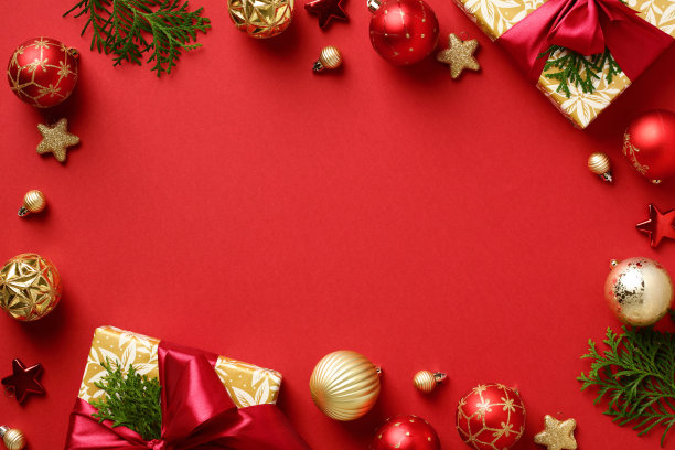圣诞帧。礼品盒上有圣诞树枝，金色的星星和红色背景上的小玩意。平铺，俯视图，复制空间。圣诞横幅模型，节日网站标题模板图片下载