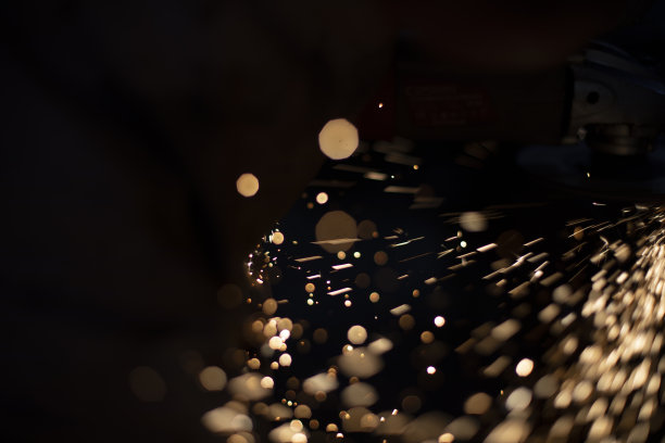 火花在黑暗。金属磨灯。研磨工的工作细节。图片下载