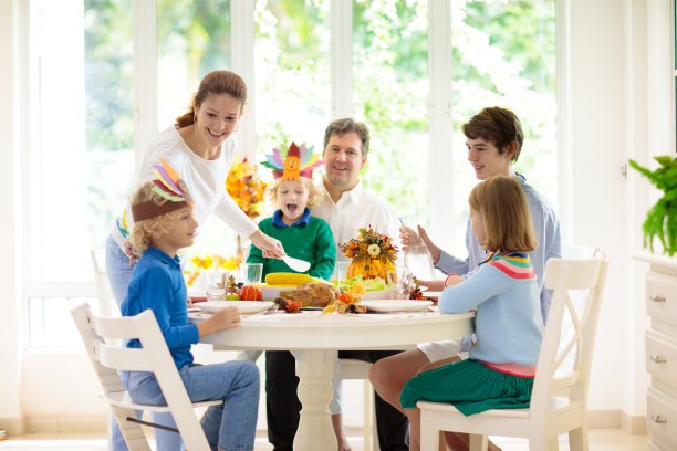 一家人带着孩子在感恩节晚餐上。火鸡图片下载