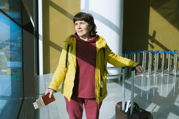 一个老妇人的肖像，带着一个手提箱，护照和登机牌。图片下载