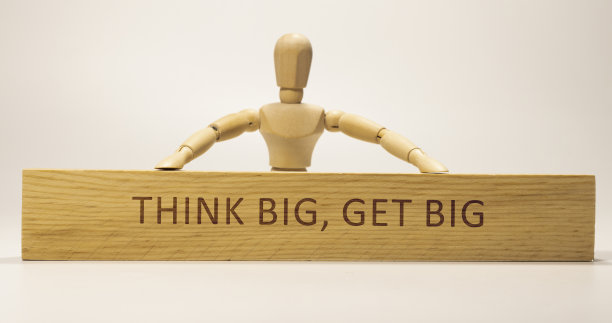 木头表面写着“Think Big, Get Big”。口号和积极的思考。图片下载