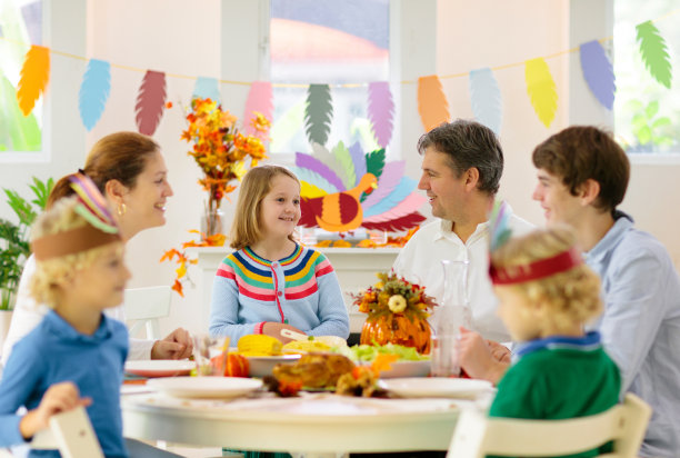 一家人带着孩子在感恩节晚餐上。火鸡图片下载