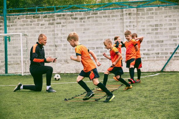 与教练进行体育训练。为体育比赛做准备。初学足球的运动员在户外体育馆里用运动器材练习。图片下载