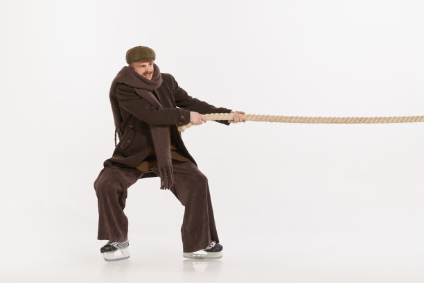 肖像年轻的情绪化的人在冬天的衣服拉绳子孤立在白色的工作室背景。竞争图片下载