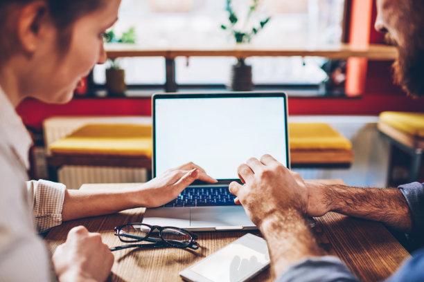 自由职业者浏览笔记本电脑与同事在咖啡馆图片下载