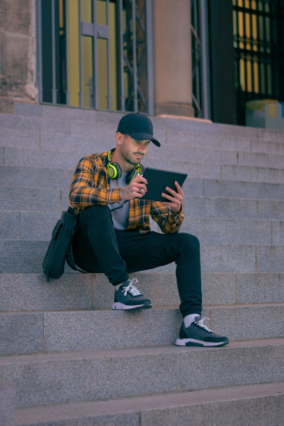 戴着帽子的人晚上用平板电脑远程工作图片下载