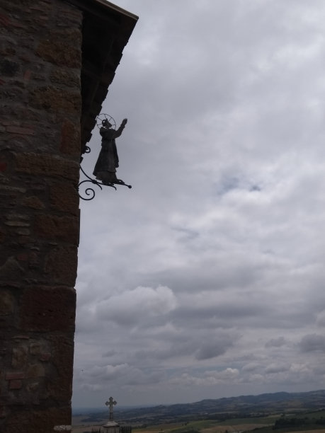 建筑侧面的圣多米尼克金属雕塑和宗教十字剪影，衬着阴云密布的天空和风景，范约，法国图片下载