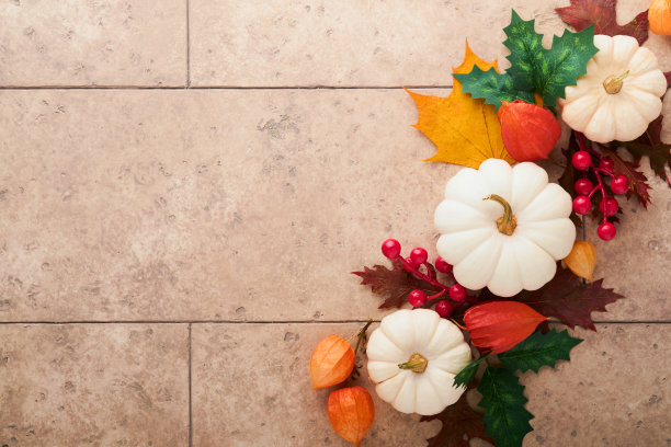 万圣节喜庆的秋天背景。秋天的装饰从南瓜，浆果，枫叶和栗子在古老的乡村石瓷砖背景。感恩节万圣节的概念。俯视图复制空间图片下载