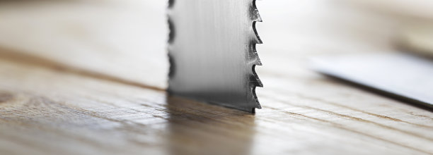 金属带锯切割橡木木板和刨花。图片下载