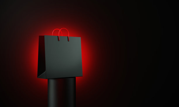 黑色购物袋坐在黑色讲台前的黑色背景图片下载