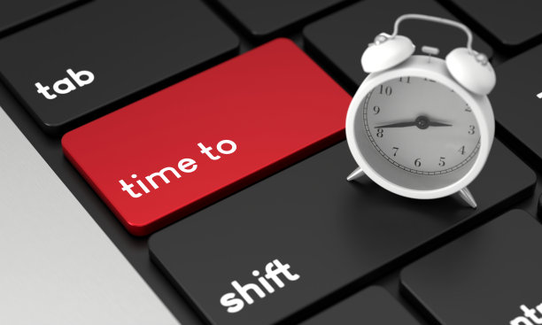 特写笔记本电脑键盘与时间按钮和闹钟图片下载