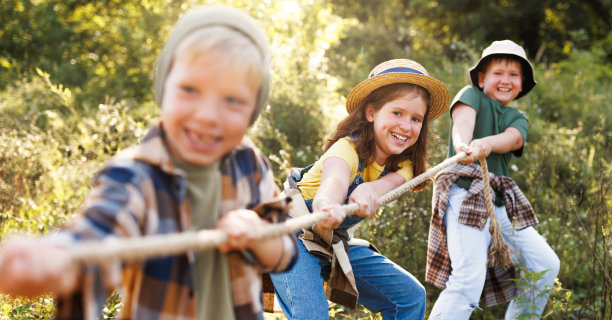 一群兴高采烈的孩子在夏日的户外拔河图片下载