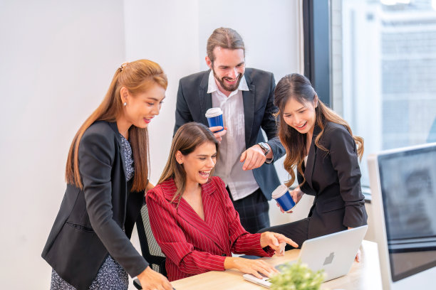 一群创业的同事，在办公室工作的员工，休息时间放松，看网上有趣的视频剪辑，开怀大笑图片下载