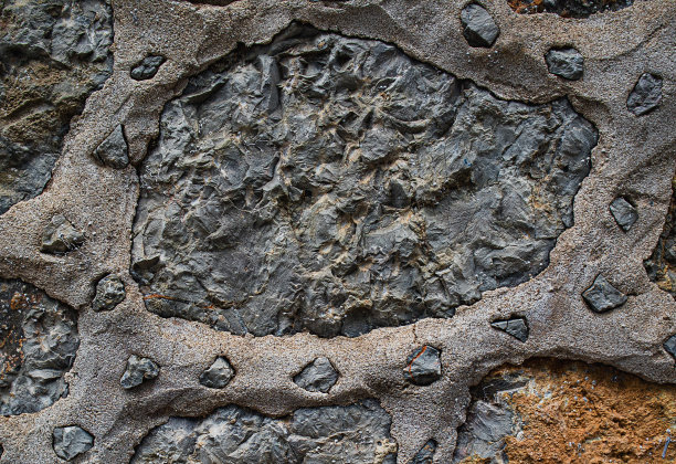 岩石纹理。黑暗的石墙。石头的背景。岩石表面具有全息、珍珠般的光泽。墙的抽象。油漆斑点。岩石表面有裂缝。抽象的纹理。图片下载