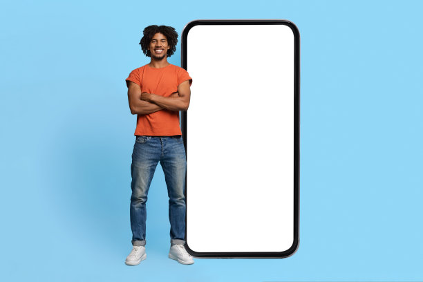 自信的黑人男子在空空的大智能手机前摆姿势图片下载