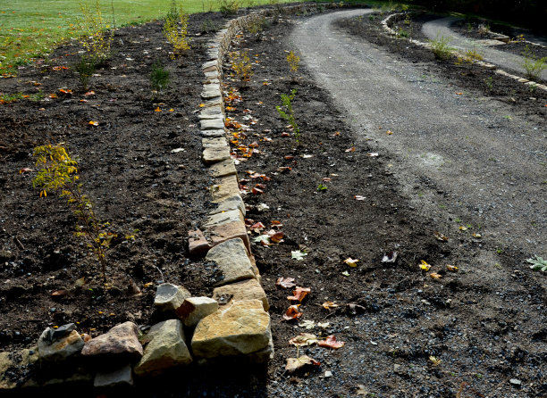 干墙作为花园的露台，在那里它保存了大量的土壤。墙是轻微弯曲的，这有助于它更好地稳定。种植多年生植物及石园、沙石图片下载