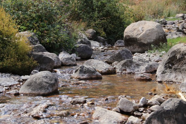 阳光明媚时穿过岩石的小溪图片下载