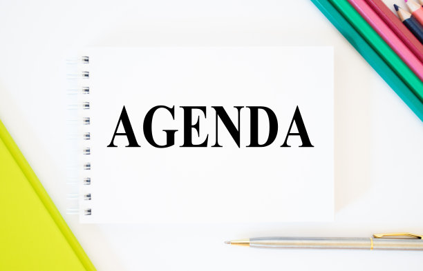 钢笔和笔记本的顶视图与议程写在白色背景与文件夹和铅笔。议程会议预约活动信息概念，议程词。明亮的画面图片下载