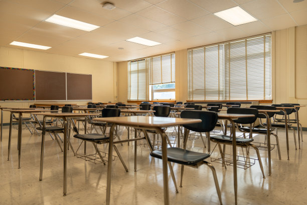 一个空的无特征的美国高中教室的例子，有桌子，窗户和黑板。图片下载
