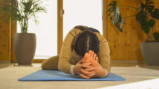 肖像:正面的亚洲妇女练习坐的头到膝盖瑜伽姿势图片下载