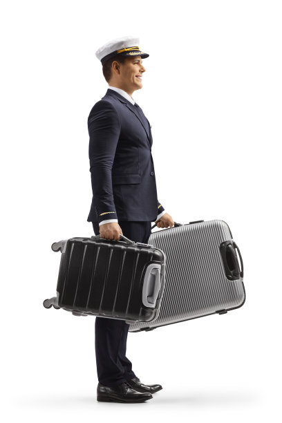 一个穿着制服的飞行员拿着行李箱的完整的侧面镜头图片下载