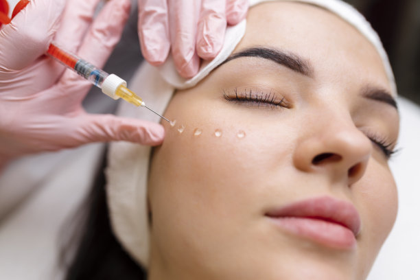 美容师在美女的脸上注射抗皱针剂。美容院的女性审美美容。图片下载