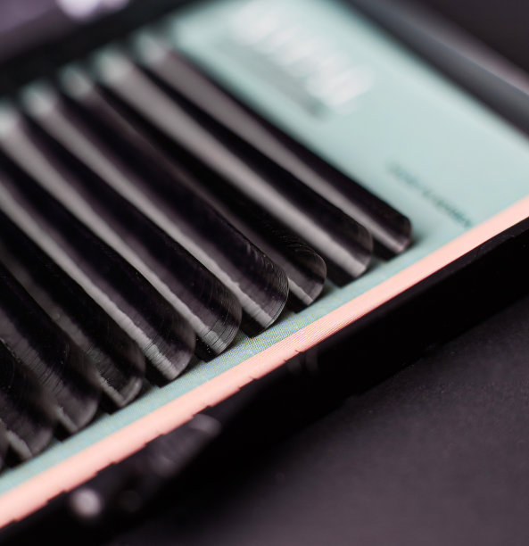 黑色的假睫毛在盒子里用于延伸，在黑色的背景下进行美丽的化妆图片下载