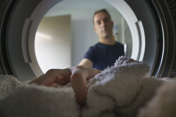 男人把手伸进前面装的洗衣机或烘干机图片下载