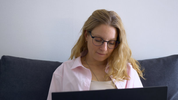 一位美丽的白人妇女在电脑前工作，累了，她摘下眼镜，揉了揉眼睛。在电脑前繁重的工作对眼睛的健康有害，会导致视力下降。图片下载