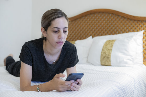 女子在酒店房间使用手机图片下载