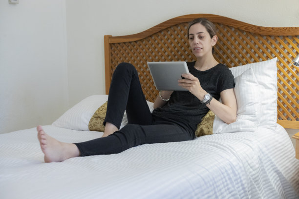 有女人在酒店房间里使用平板电脑图片下载