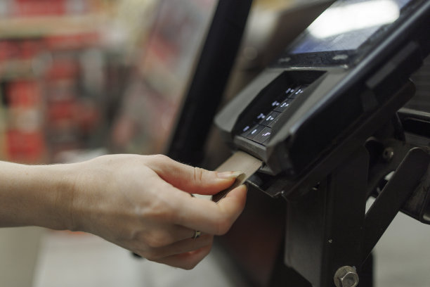 用信用卡付款。商店里的信用卡机付款。聚焦在卡片上，与散焦背景。图片下载