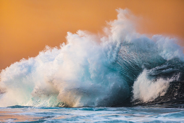 海洋风暴膨胀打破明亮的高对比金色的晨光与橙色的天空背景图片下载