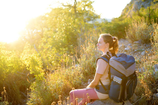 年轻女子在乡间徒步旅行。背包徒步旅行图片下载