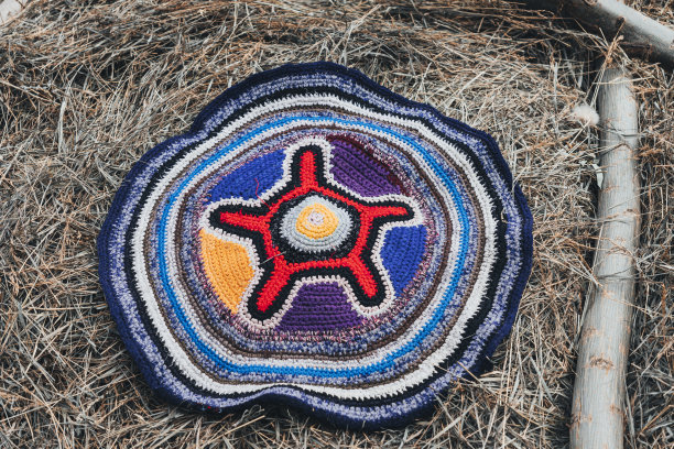用旧磁带在干草堆上手工制作的地毯。乡村生活的概念。在俄罗斯村庄里晾晒地毯。图片下载