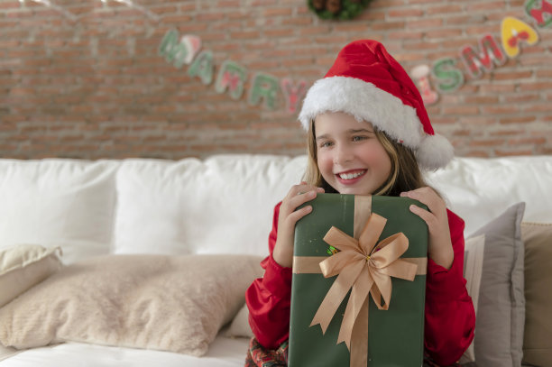 一个拿着圣诞礼物的小孩。图片下载