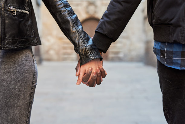一对情侣在户外牵手的特写镜头。图片下载