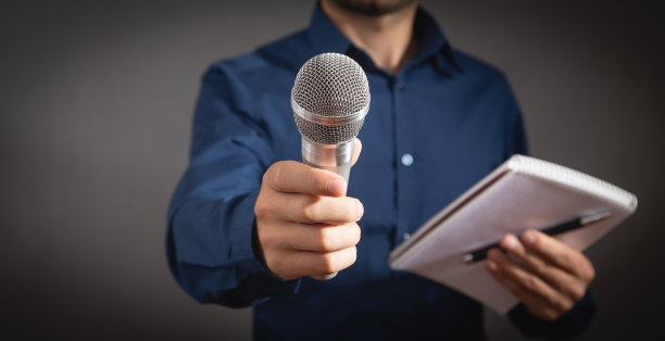 白人记者拿着麦克风、笔记本和笔。图片下载
