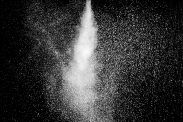 白色卷曲蒸汽流与水滴在黑色背景。喷洒水。水花和水滴图片下载
