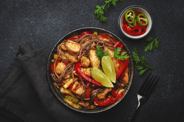 亚洲菜，炒面配鸡肉、蔬菜和芝麻。黑色厨房桌面背景，俯视图，复制空间图片下载