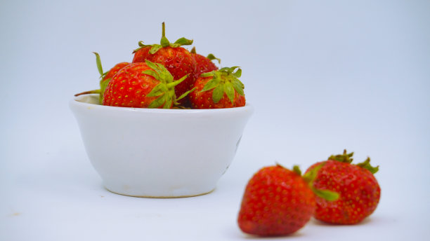 新鲜成熟的美味草莓放在白色的碗里图片下载