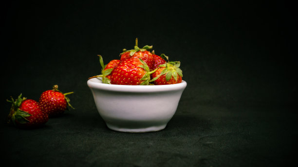 新鲜成熟的美味草莓放在白色的碗里图片下载