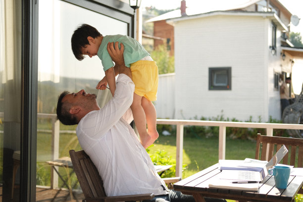一名穿着便装的男子在田园诗般的乡村花园用笔记本电脑工作。图片下载