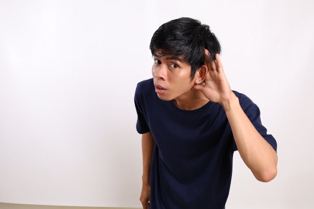 年轻的亚洲人把手放在耳朵附近。八卦的概念。孤立的白色背景与复制空间图片下载