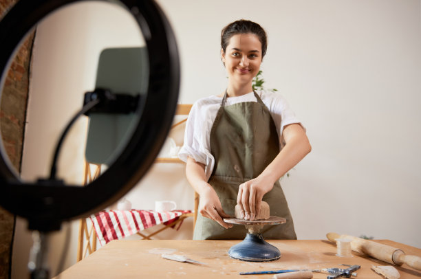 迷人的微笑女孩，陶艺大师与用品录制vlog在家庭工作室。爱好和休闲活动。远程培训，在线课程图片下载