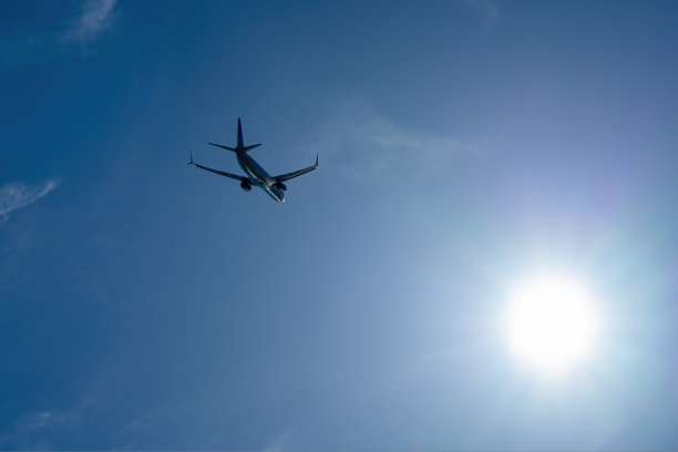 飞机正以蓝天和阳光为背景飞行图片下载