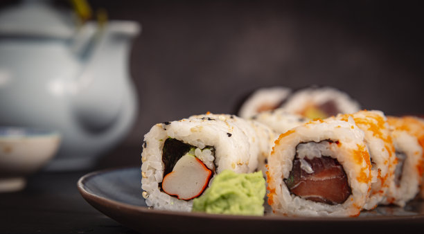 在餐厅餐桌上摆放生鱼片和寿司卷图片下载