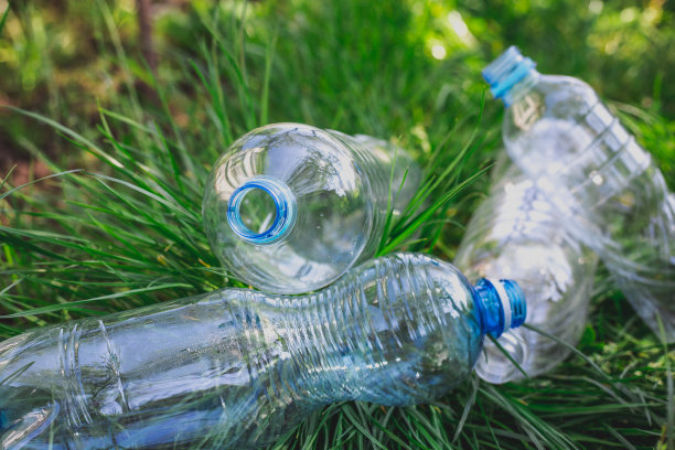 塑料瓶在草地上，环境污染，环境问题，用塑料破坏生态系统。垃圾,废物图片下载
