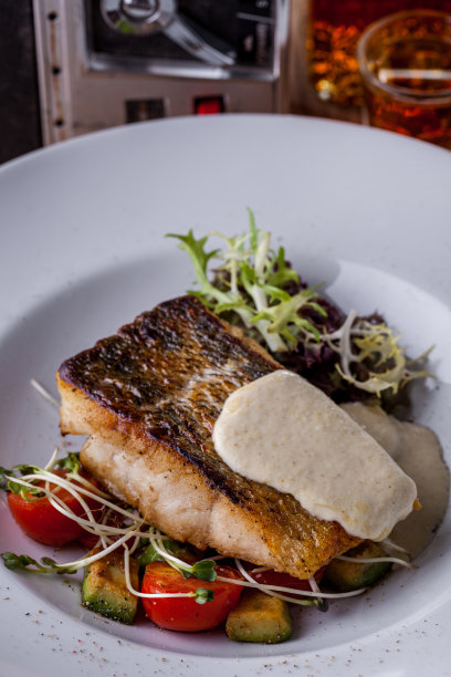 炸塞巴西配土豆泥，脆皮沙拉，嫩枝，圣女果放在白色圆盘里。垂直方向图片下载