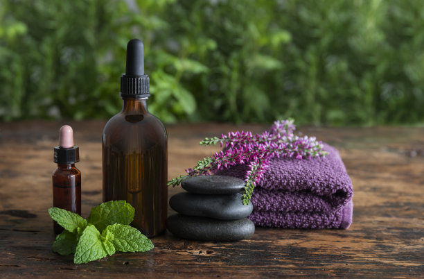 静物草药瓶与鲜花，新鲜草药，毛巾和平衡石头图片下载